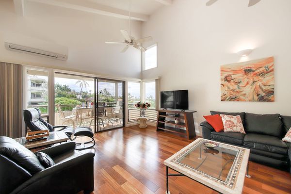 Bright Living Room with Vaulted Ceilings, Leather Seating, and Patio Access