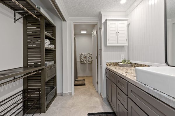Full bathroom features long vanity bright mirror and walk-in shower