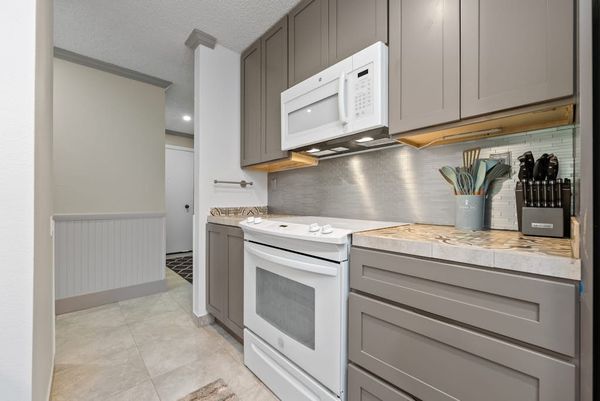 Kitchen peninsula provides ample prep space beneath stylish pendant lighting