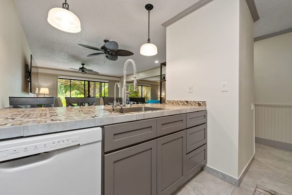 Bright kitchen showcases sink generous counters and modern cabinetry
