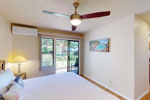 Bright Bedroom with King Bed, Split AC Unit, Ceiling Fan, and Patio Access