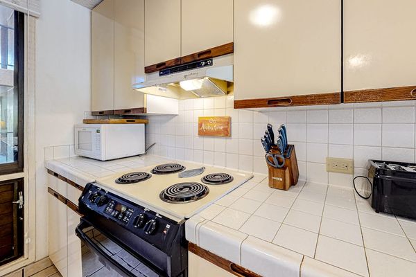 Well-equipped kitchen with ample cabinet storage, cookware, and convenient appliances