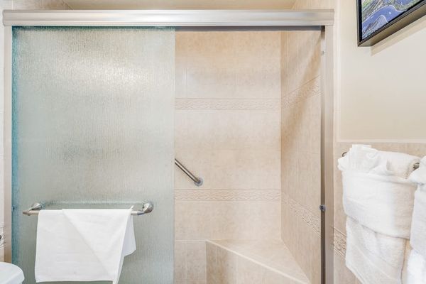 Glass shower enclosure with fresh plush towels provided