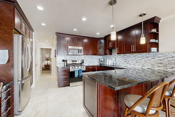 Kitchen dining space shares warm cabinetry and bright natural light