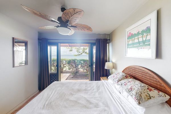 First bedroom with queen bed, ceiling fan, outdoor access, and beautiful views