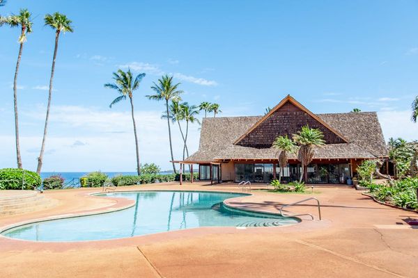 Resort pool and pavilion overlook palm trees and Pacific Ocean