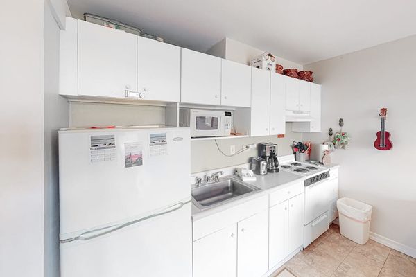 Spacious kitchen showcases refrigerator microwave oven and generous counter space