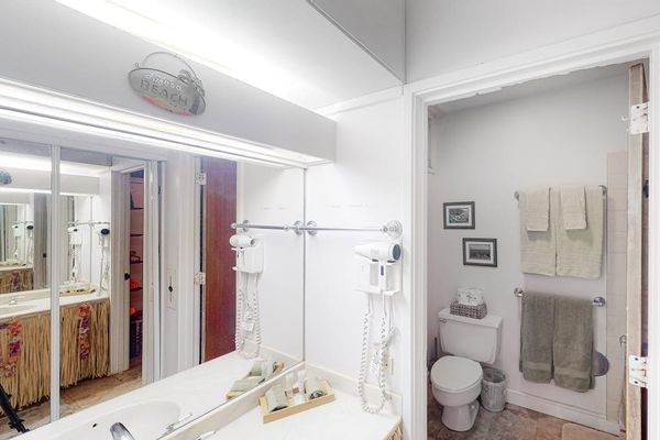 Bright bathroom features vanity mirror shower and clean contemporary finishes