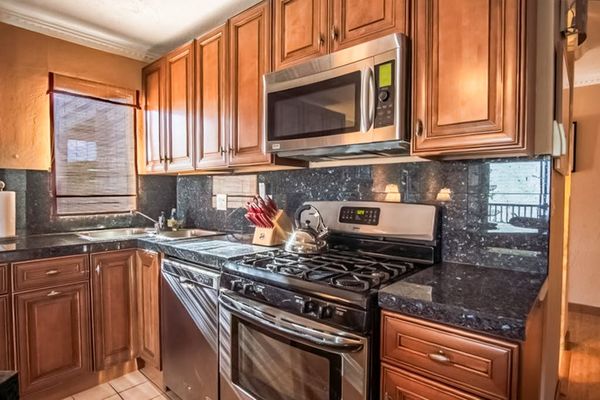 Kitchen includes appliances wood cabinetry range and ample counter space