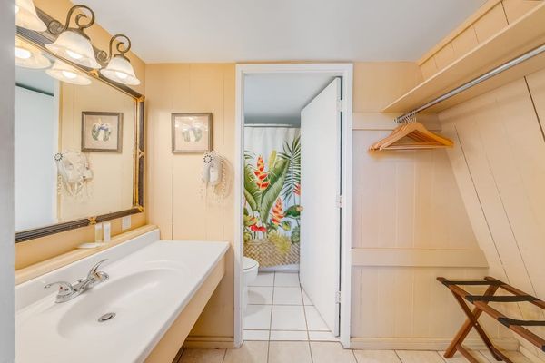 Full bathroom vanity offers mirror storage and bright wood finishes