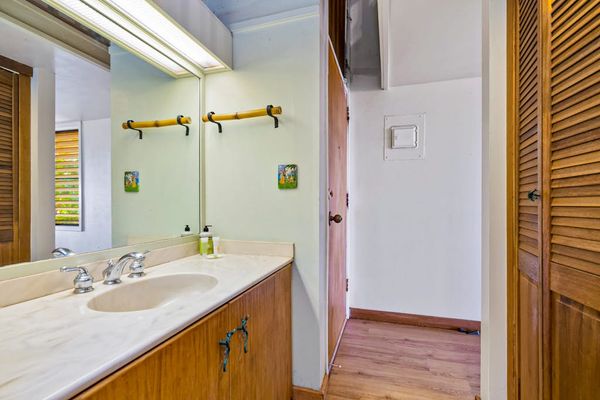 Spacious bathroom features dual sinks wood cabinetry and tiled surfaces