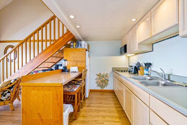 Well-equipped kitchen features wooden cabinets counters and useful appliances throughout