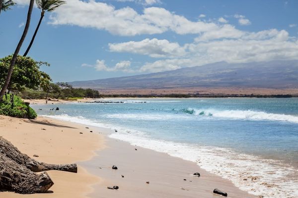 Crystal-clear turquoise waters gently wash onto pristine white sandy beaches.