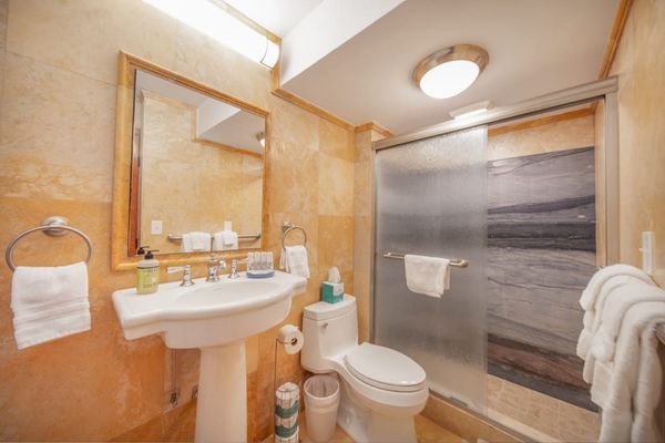 Full bathroom with a walk-in shower, fresh towels, and complimentary essentials for a comfortable stay.
