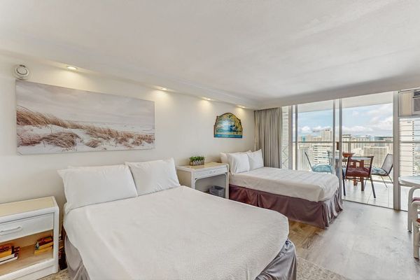 The open-concept studio features two full sized beds and direct access to the balcony.