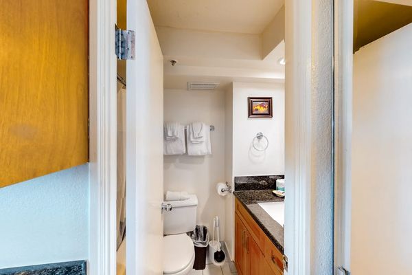 The private bathroom offers a functional design complete with a toilet, fresh towels, and a vanity area.