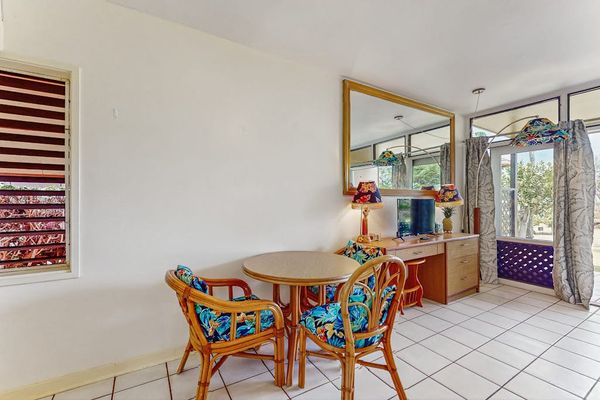 Dining area offers table, colorful chairs, windows, and garden access