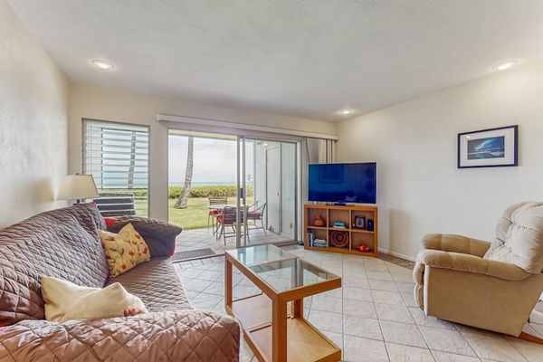 Living room features sofa, armchairs, television, coffee table, and windows