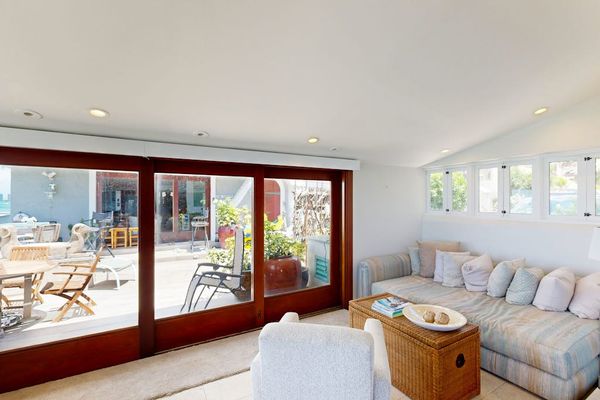 Bright living room showcases breathtaking water views through floor-to-ceiling glass every day