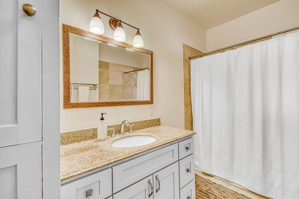 Full bathroom offers a shower and tub combination with bright vanity lighting