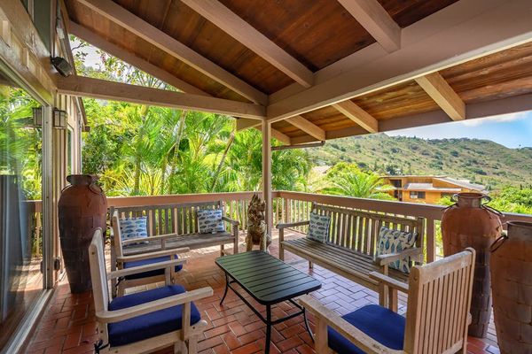 Lanai bordered by leafy greenery for outdoor seating
