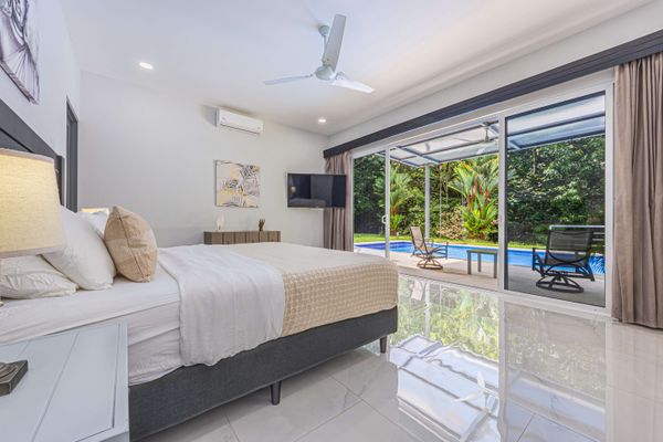 Master Suite with A/C, smart TV, ceiling fan, en-suite bathroom and patio+pool access.