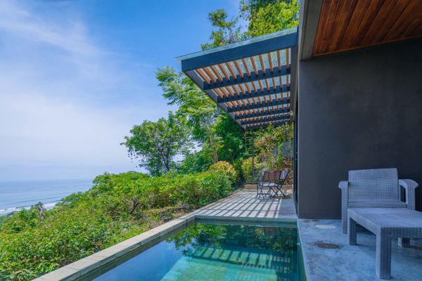 Unwind beside the private pool, surrounded by lush greenery and coastal views.