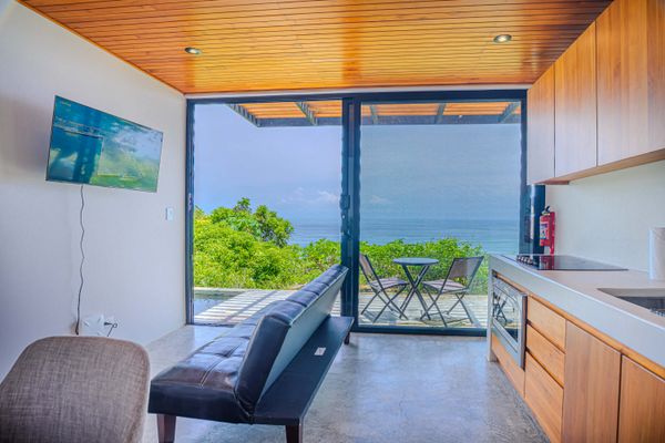 Living area with large sliding doors opening to the ocean-view terrace.