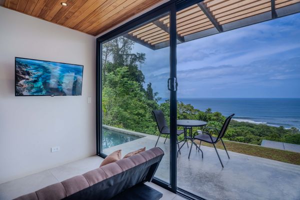 Large sliding doors fill the space with light and connect the interior to the ocean-view terrace.