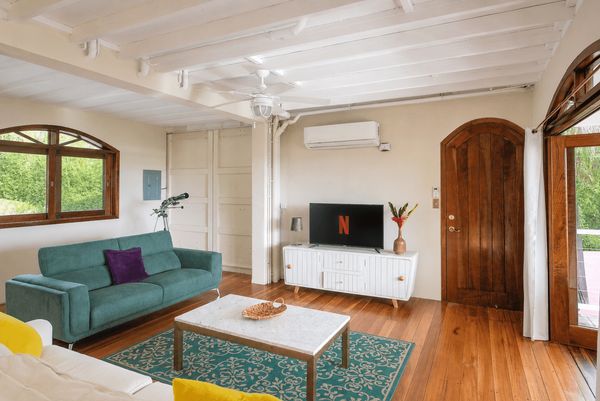 The Living Room/TV Room has a SmartTV, A/C, ceiling fan, floor-to-ceiling patio doors.