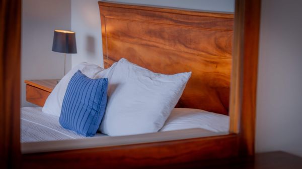 Cozy bedding and natural wood textures create a warm, relaxing bedroom atmosphere.