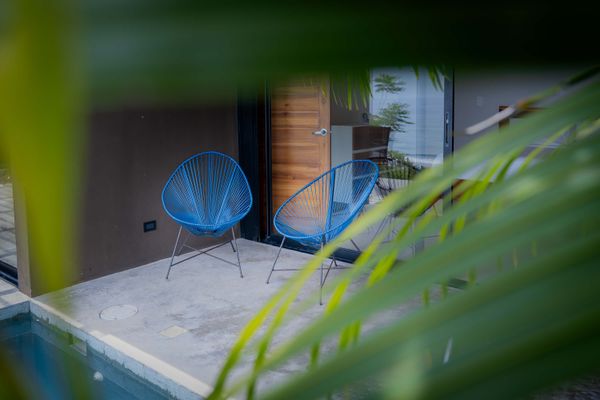 Cozy terrace seating surrounded by tropical greenery.