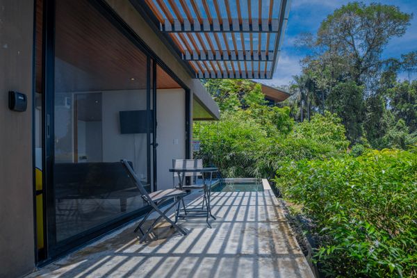 Private terrace dining area surrounded by lush greenery.
