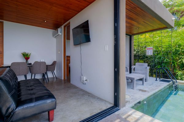 Dining area with kitchen access, air conditioning, and warm wood accents.