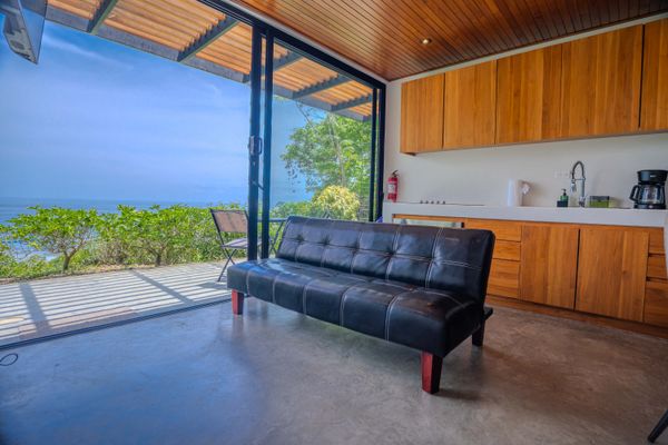 Comfortable living space with sofa, kitchen access, and ocean views.