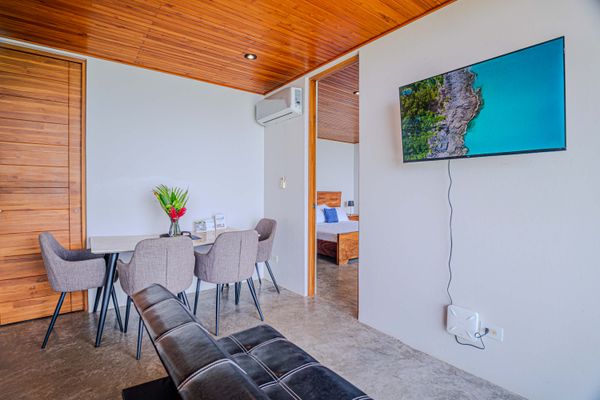 Comfortable dining and living area with TV, natural light, and modern finishes.