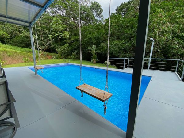 charming swing by the pool, perfect for lounging and enjoying the surroundings.