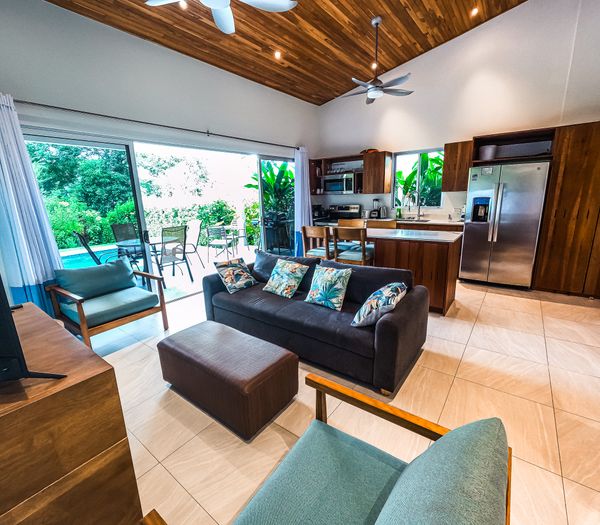 A cozy living room with large windows offering stunning views of the pool.