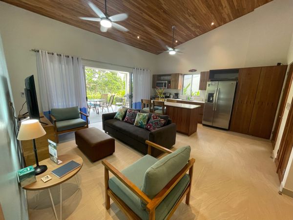 Amazing living room and kitchen with access to the patio and the pool. The living room has ceiling fan.