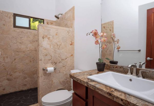 An organized, modern bathroom with a spacious shower, minimalist decor, and thoughtful lighting.