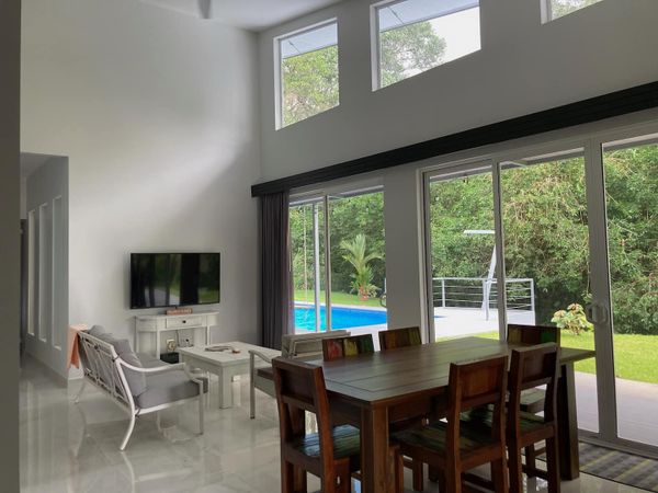 spacious living area, designed with large windows that frame the pool perfectly.