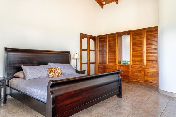 Owner's Suite has king-sized bed, en-suite bathroom, private patio/pool access, air conditioning, ceiling fan, office desk.