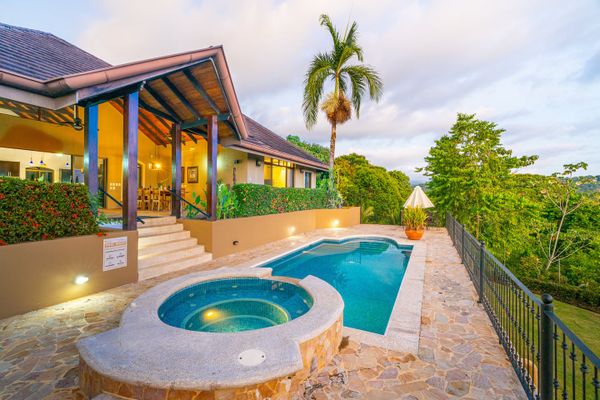 The soft afternoon light bathes the house and pool, creating a warm, inviting glow.