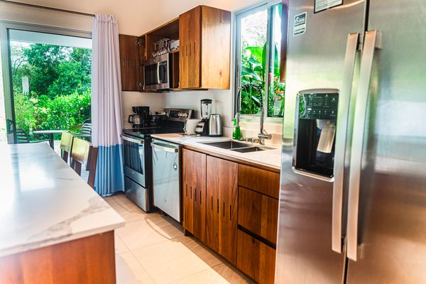 A cozy kitchen that opens up to a beautiful poolside view, blending indoor and outdoor living.