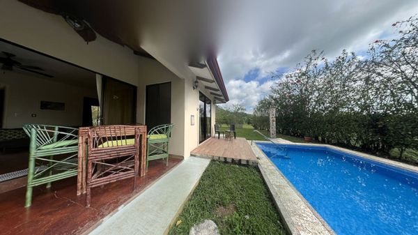 The pool area is framed by a beautiful garden, offering both privacy and serenity.