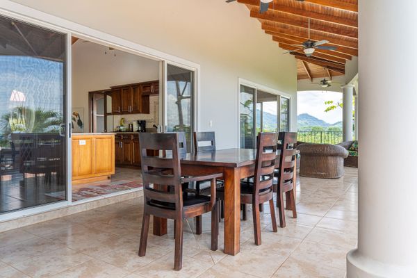 charming seating area with a table and chairs next to the pool.