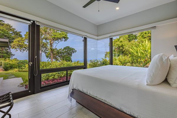 Suite #1 - Amazing views of the ocean, sunset,  swimming pool, waterfall and patio from the king-size bed, A/C, ceiling fan, en-suite bathroom with shower, bathtub, and sinks.