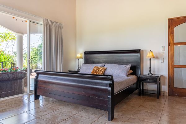 Owner's Suite has king-sized bed, en-suite bathroom, private patio/pool access, air conditioning, ceiling fan, office desk.