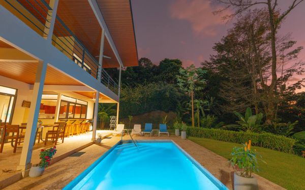 The house and pool glow beautifully at night, with soft lighting creating a tranquil ambiance.