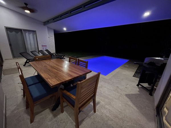 Incredible pool area with new wooden table and chairs.